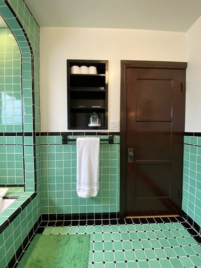 Restored three-panel door and built-in niche with towels in vintage tile bathroom — Fred Beese Builds